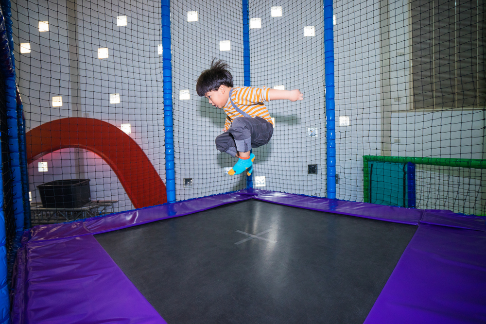 A young boy jumping in a trampoline park