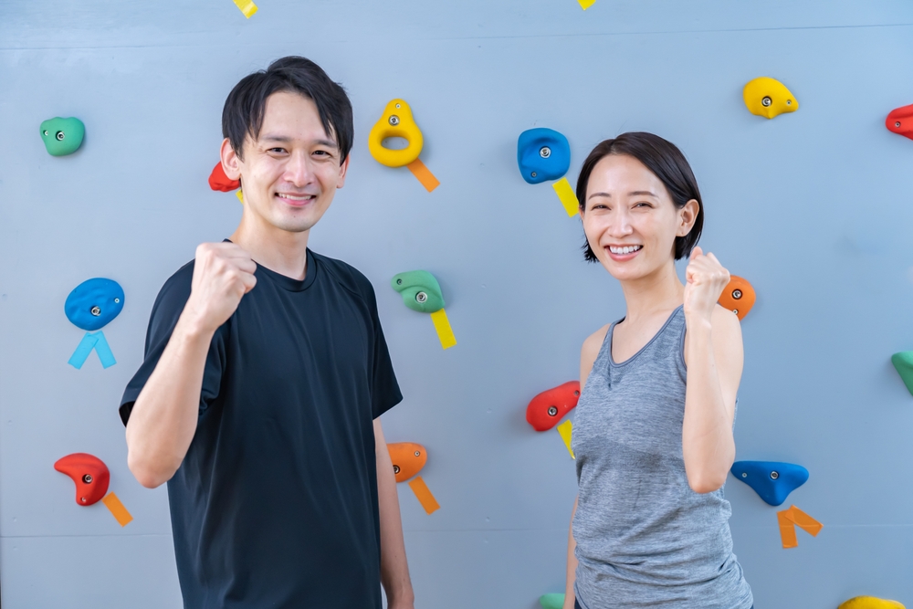 Two people in front of a climbing wall